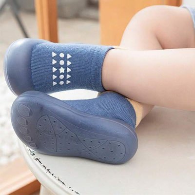 chaussure bebe souple bleue sur pieds de bebe croise