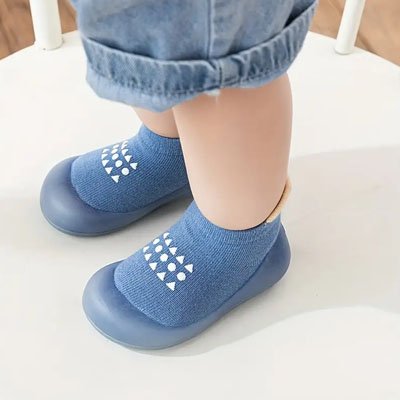 chaussure bebe souple bleue sur pieds de bebe debout