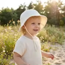 enfant portant bebe chapeau blanc