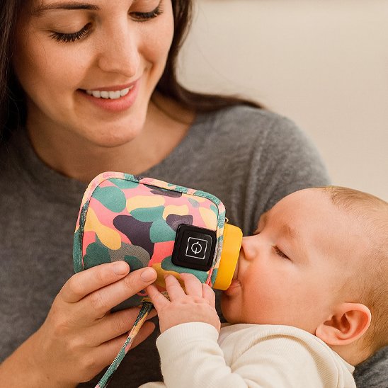 maman nourrissant bebe avec biberon dans chauffe biberon portable